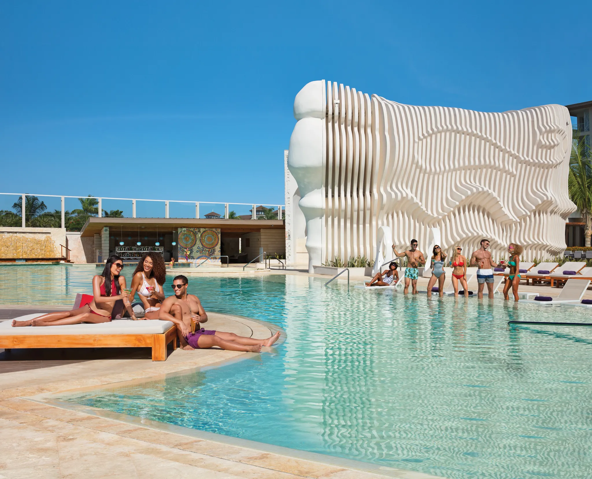 Guests relaxing and socializing around the main pool at Breathless Montego Bay during the day.