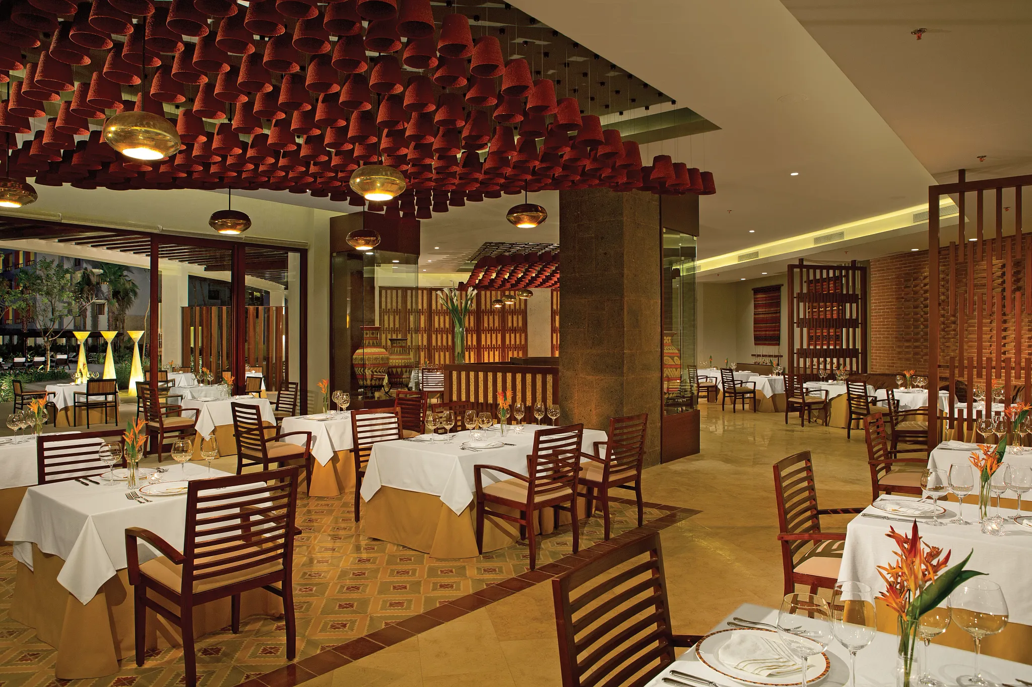 El Patio Mexican restaurant at Secrets Playa Mujeres Golf & Spa Resort featuring elegant dining tables and traditional décor in a warm hacienda-style setting.