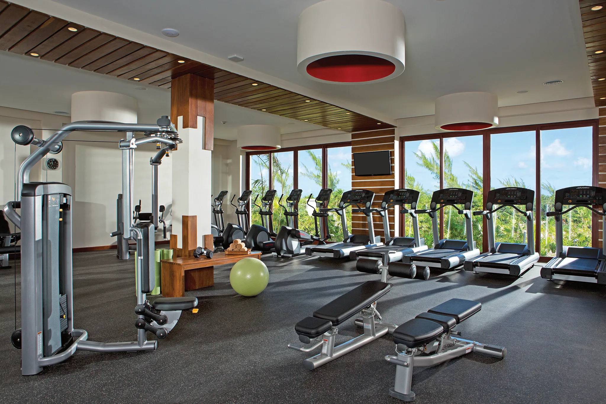 Modern fitness center with treadmills and strength equipment at Secrets Playa Mujeres Golf & Spa Resort.