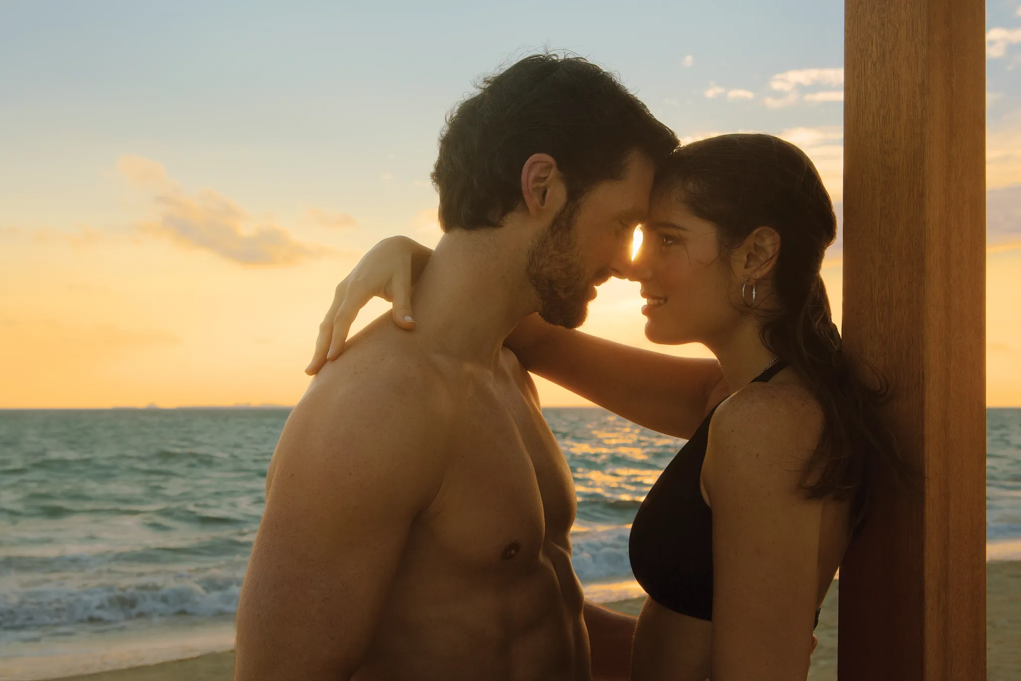 Couple enjoying a romantic beach cabana at sunset at Secrets Playa Mujeres Golf & Spa Resort.
