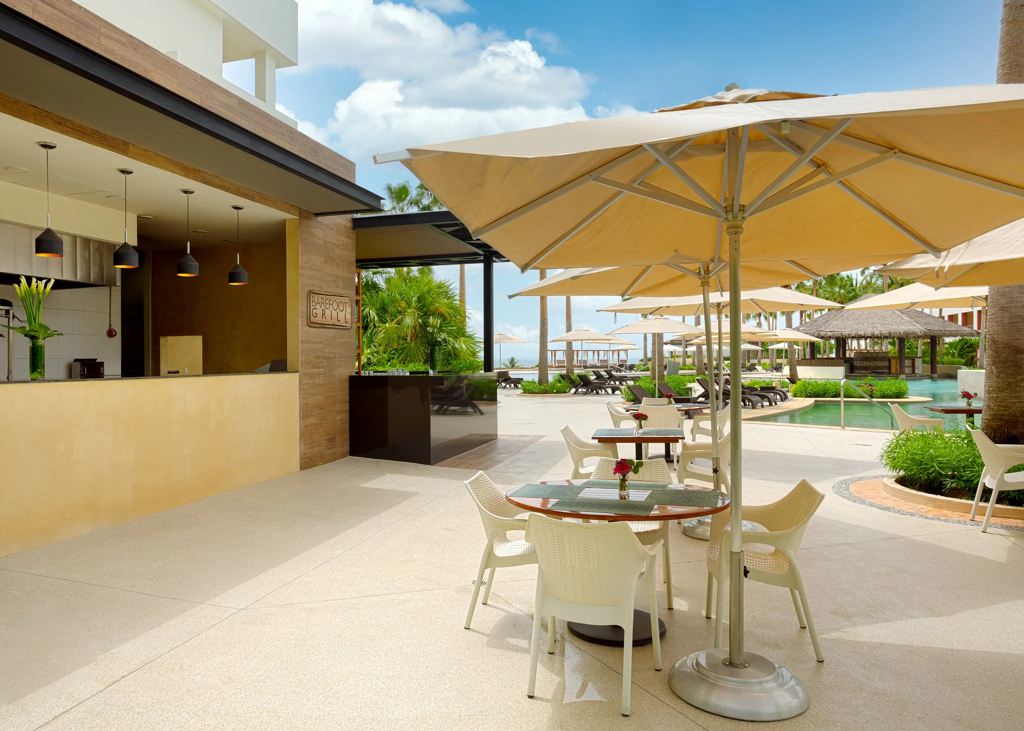 Seaside Grill poolside restaurant at Secrets Playa Mujeres Golf & Spa Resort featuring outdoor patio seating with umbrellas and views of the resort pool.