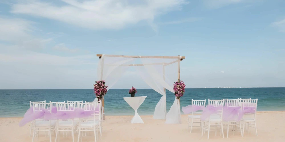 Beach wedding ceremony setup with arch and ocean view at Secrets Playa Mujeres Golf & Spa Resort