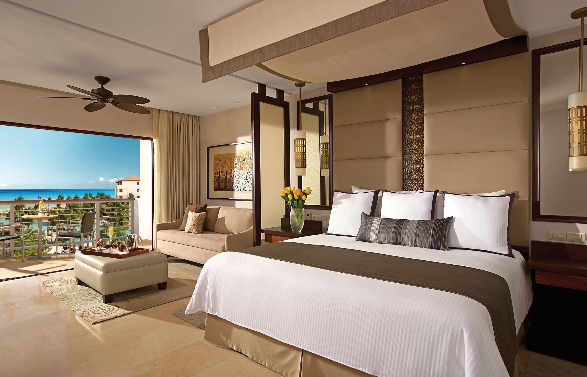 Junior Suite Ocean View king bedroom with balcony and Caribbean Sea views at Secrets Playa Mujeres Golf & Spa Resort.