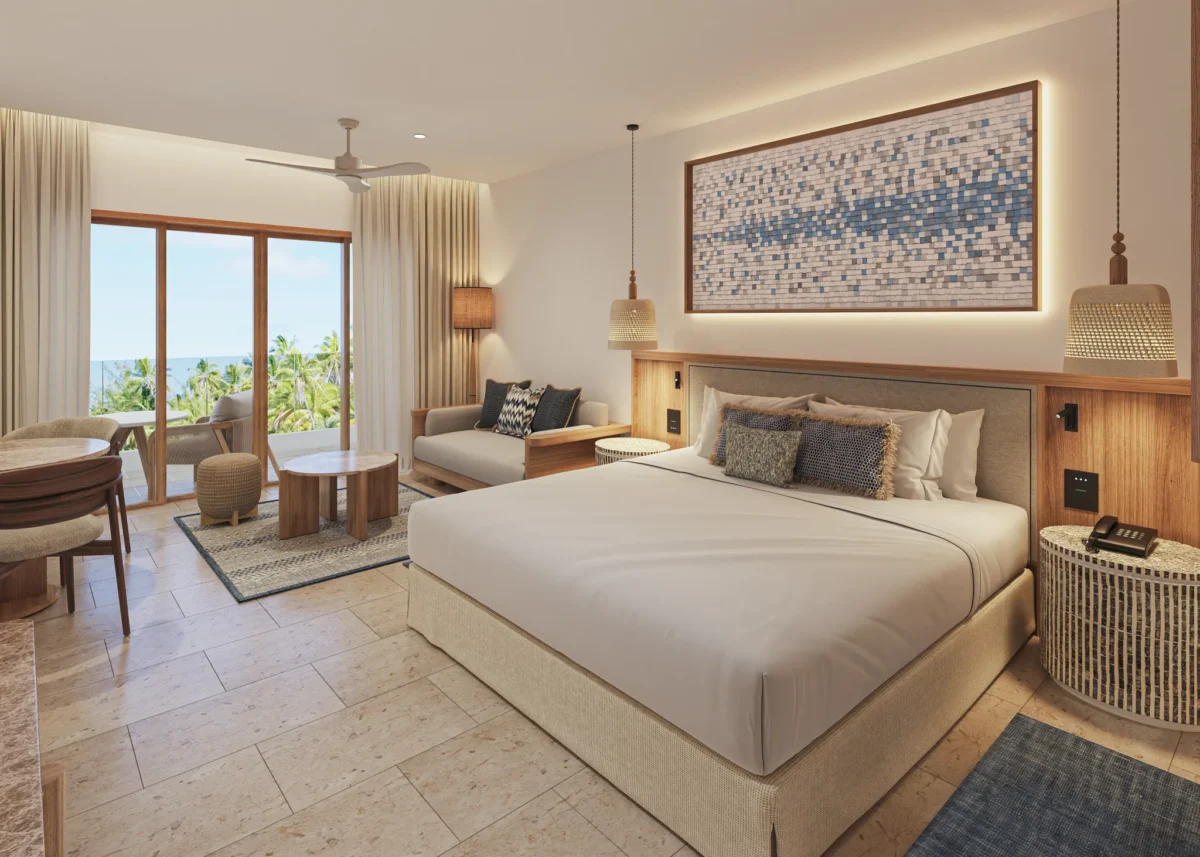 Junior Suite Partial Ocean View bedroom with king bed, sitting area, and balcony at Secrets Playa Mujeres Golf & Spa Resort.