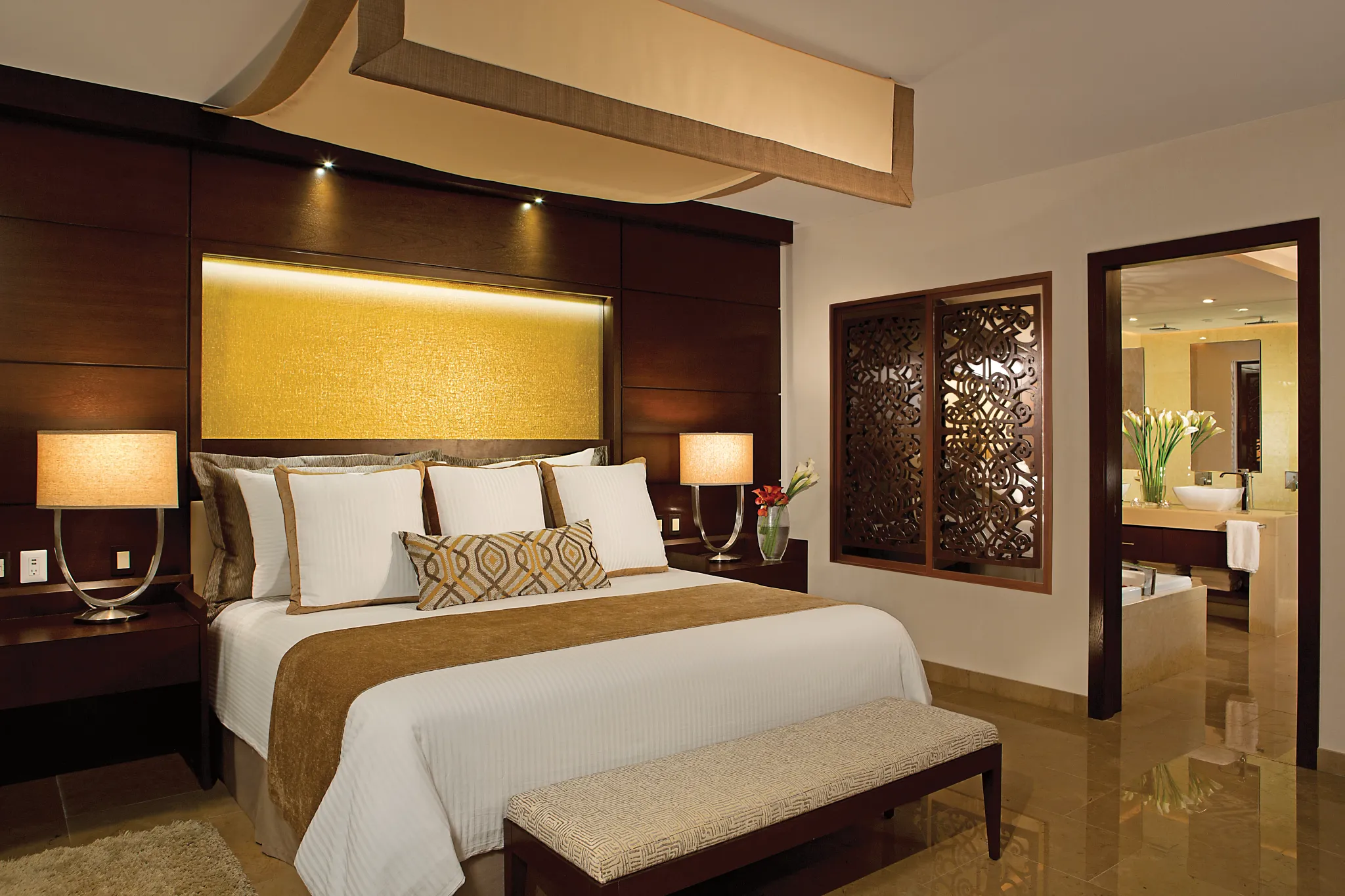 Preferred Club Master Suite Ocean Front king bedroom with decorative wood accents at Secrets Playa Mujeres Golf & Spa Resort.