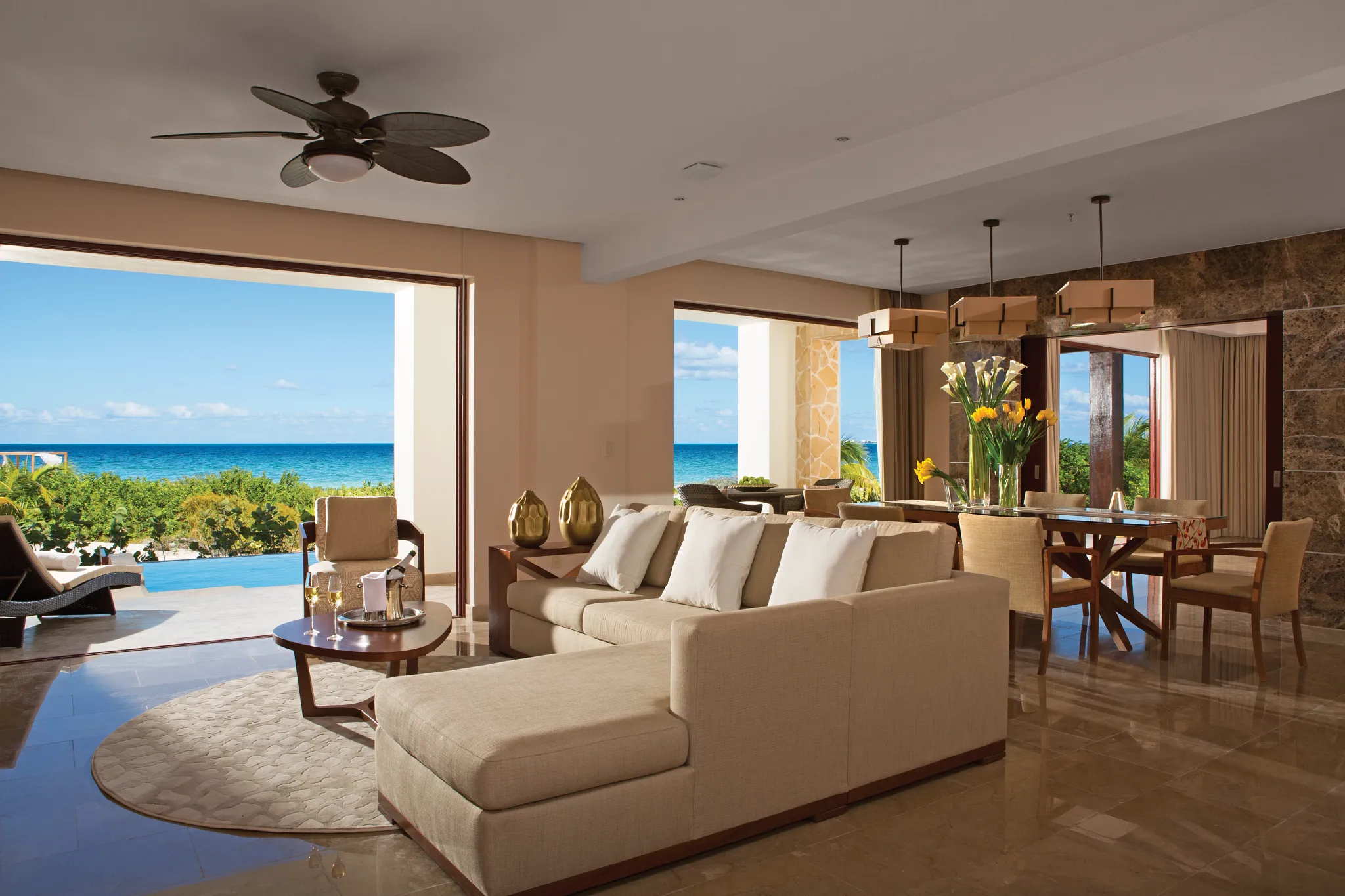 Presidential Suite oceanfront living room with sofa and dining area at Secrets Playa Mujeres Golf & Spa Resort.
