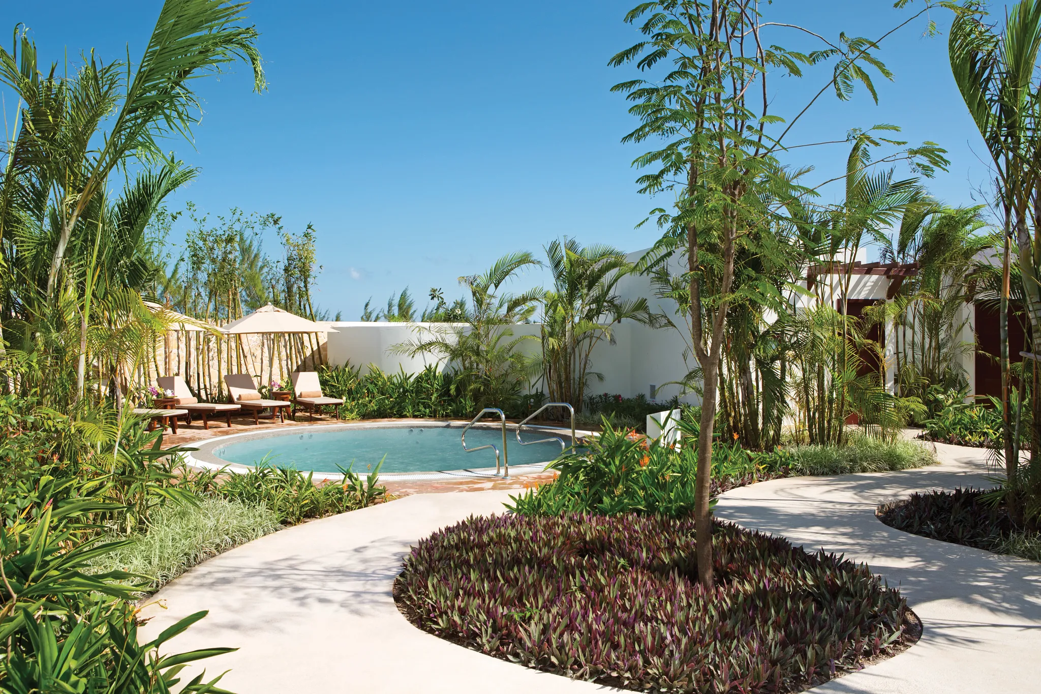 Outdoor spa whirlpool surrounded by tropical landscaping at Secrets Playa Mujeres Golf & Spa Resort.