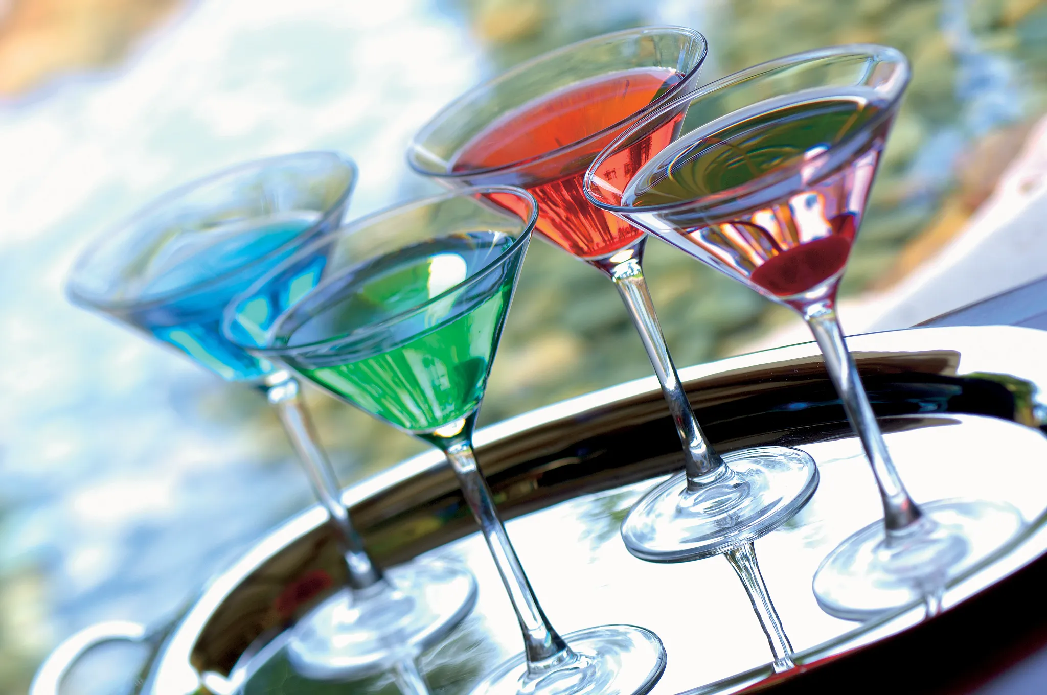 Colorful martini cocktails at Sugar Reef Poolside Bar at Secrets Playa Mujeres Golf & Spa Resort overlooking the resort pool.